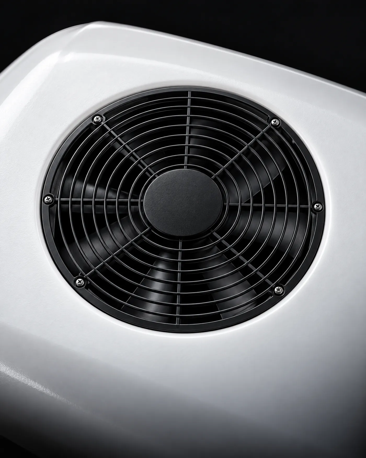 Detalhe do ventilador redondo preto, com anéis e raios, no topo branco do aparelho